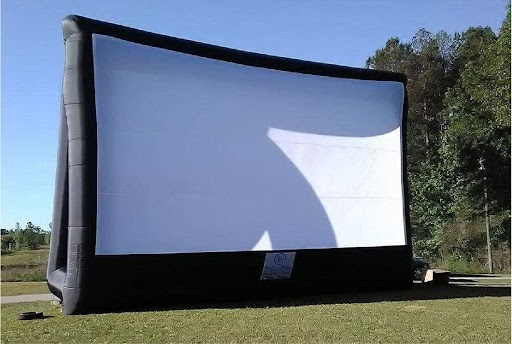 People enjoying an outdoor movie night with an inflatable screen in New York.